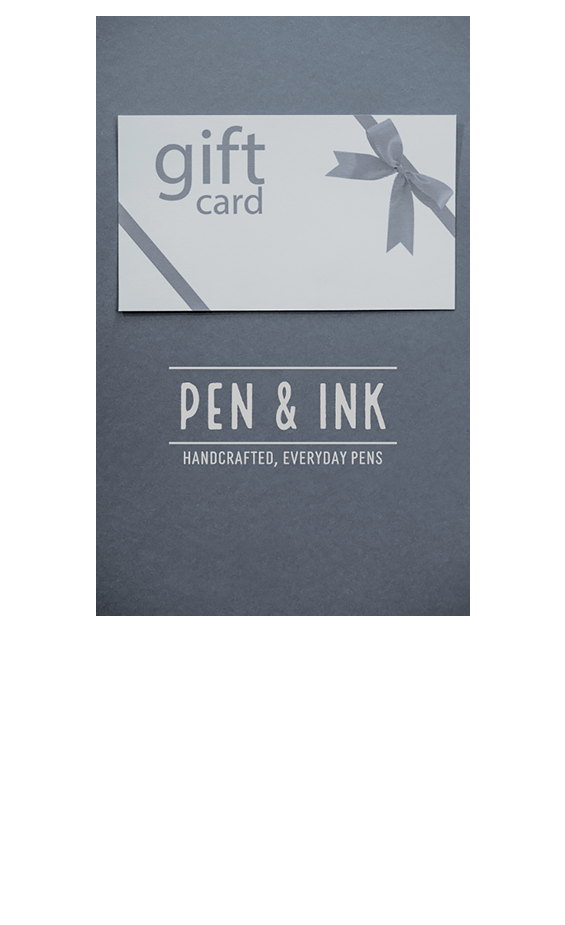 Pen & Ink gift card envelope with a ribbon design, placed on a dark grey background with the Pen & Ink logo and tagline 'Handcrafted, Everyday Pens' below.