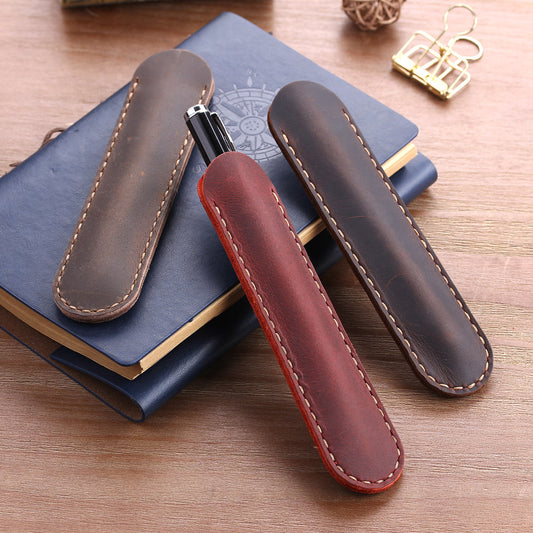 Hand-stitched Italian distressed leather pen sleeves in red, coffee, and brown, shown on a journal with a wood background – rustic single pen holders