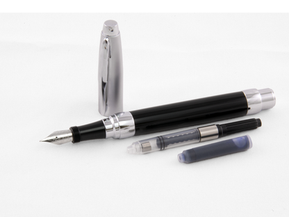 Presimo Fountain Pen in Tuxedo Black disassembled with chrome cap, ink converter, cartridge, and nib shown on white surface